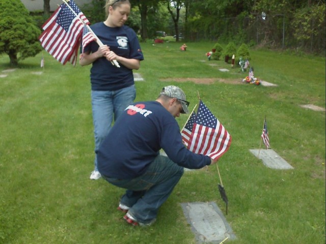 Tara Helmke and Matt Younghans place flags at the gravesites of deceased firefighters.  5/24/08