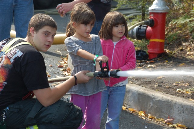 Firefighter Joe Pacella supervises children using the fire hose at the NFD open house, 10/11/09.  Photo:  Tommy Bierds